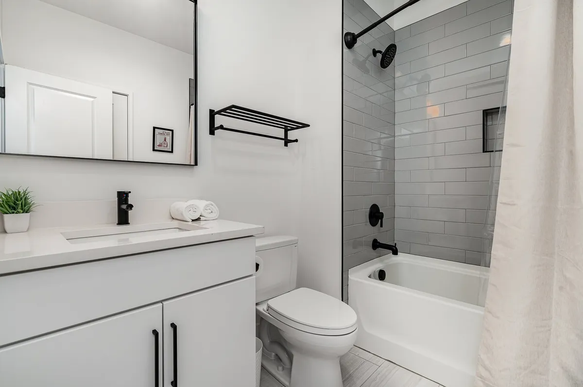 A serene bathroom scene with a vanity, sink, towels, and a glass-enclosed shower. The area is well-lit and inviting, perfect for refreshing routines and self-care.